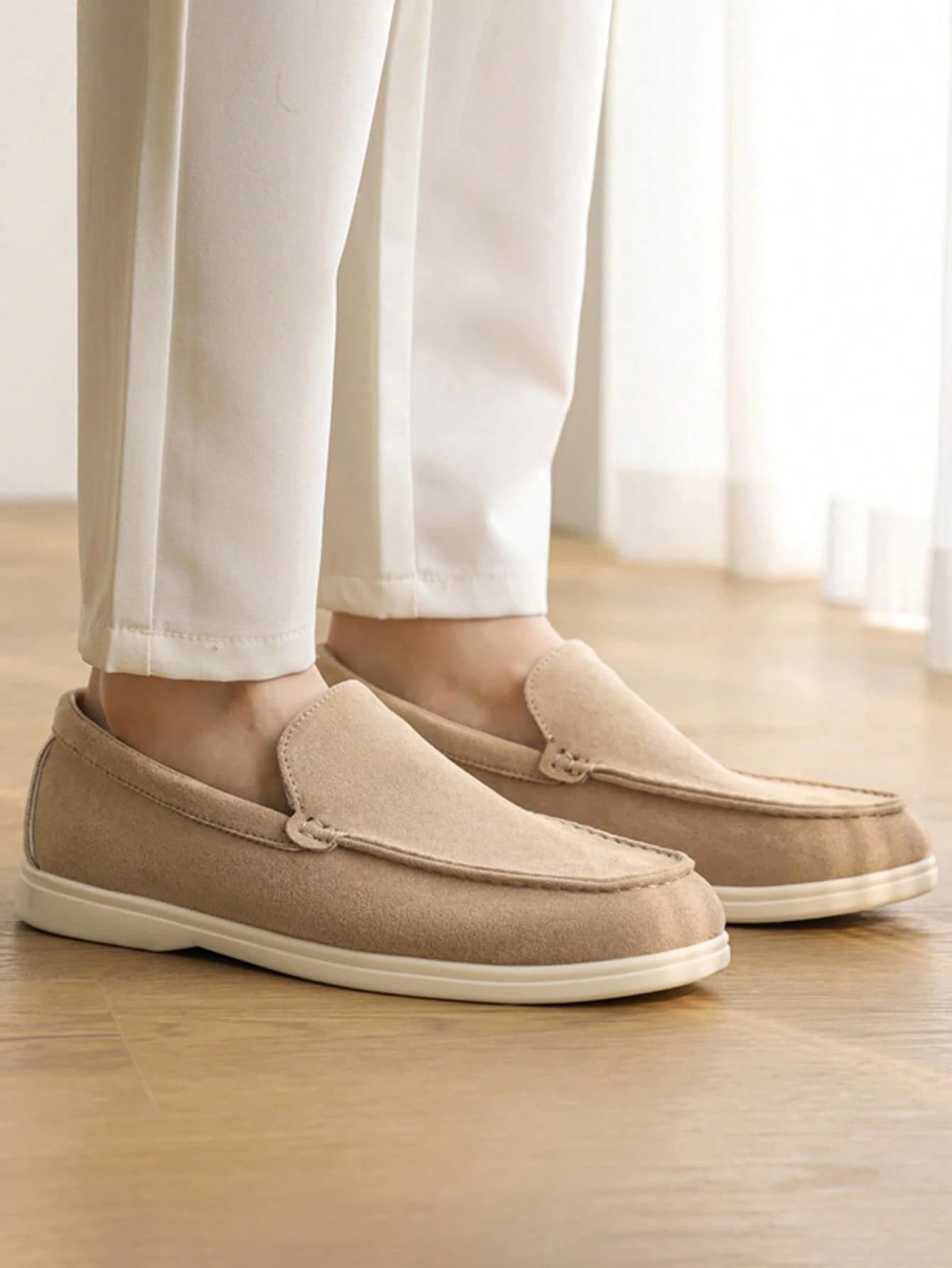 The same loafers worn with cream trousers, seen from the front.