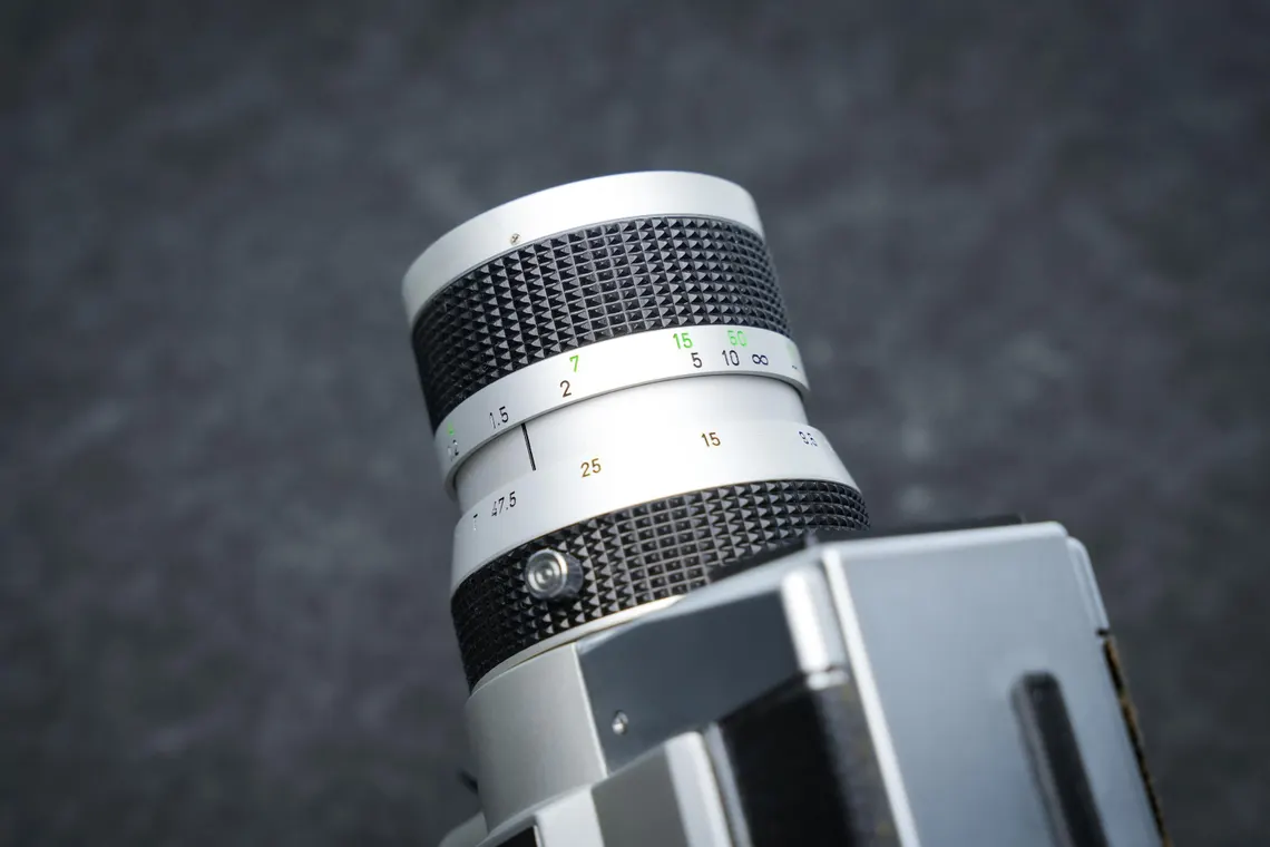 Close-up of the zoom lens barrel on the Canon Auto Zoom 518 SV, showing the focus and aperture markings in white and green.